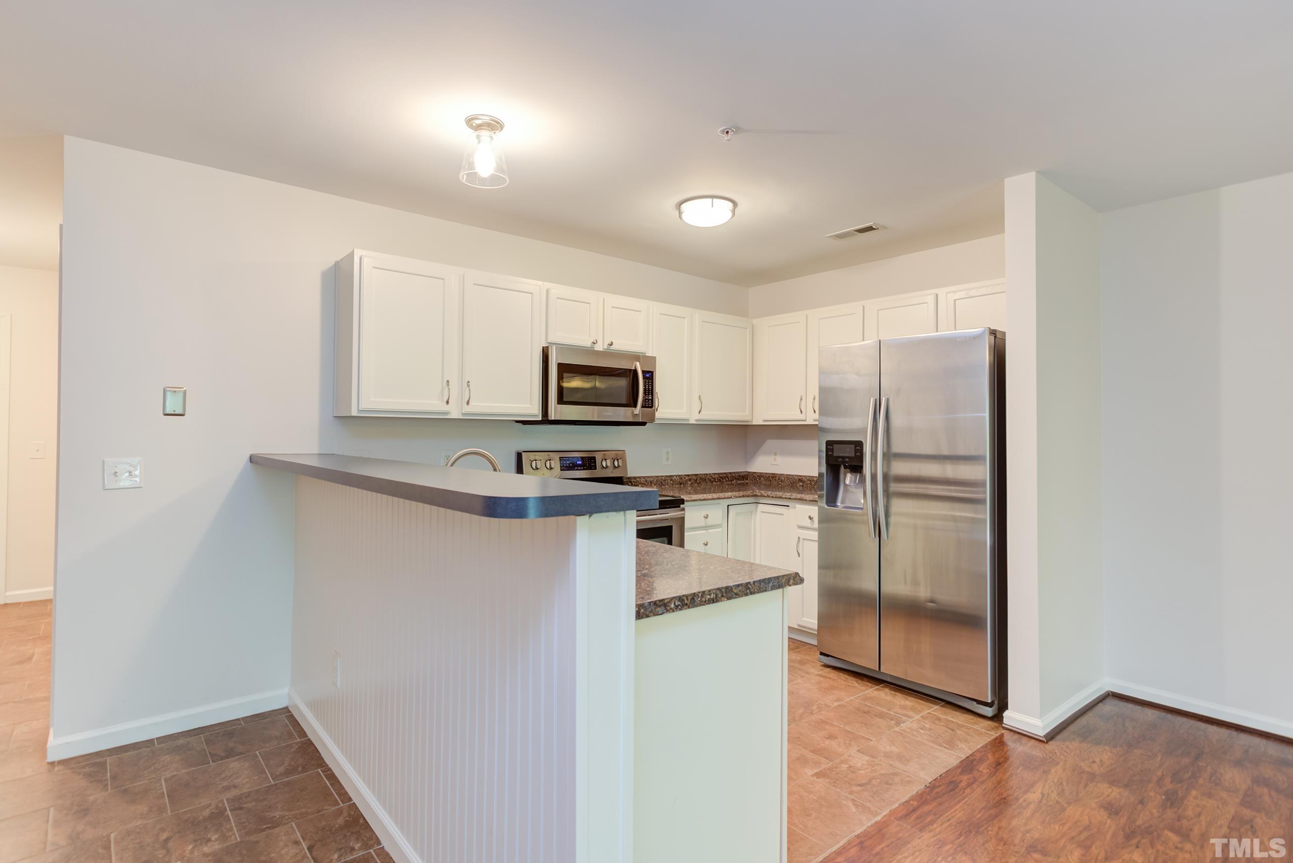 2801 Trailwood Pines Lane, Unit 102 Raleigh, NC 27603 - Photo 14 of 27 a kitchen with stainless steel appliances a refrigerator stove microwave and sink