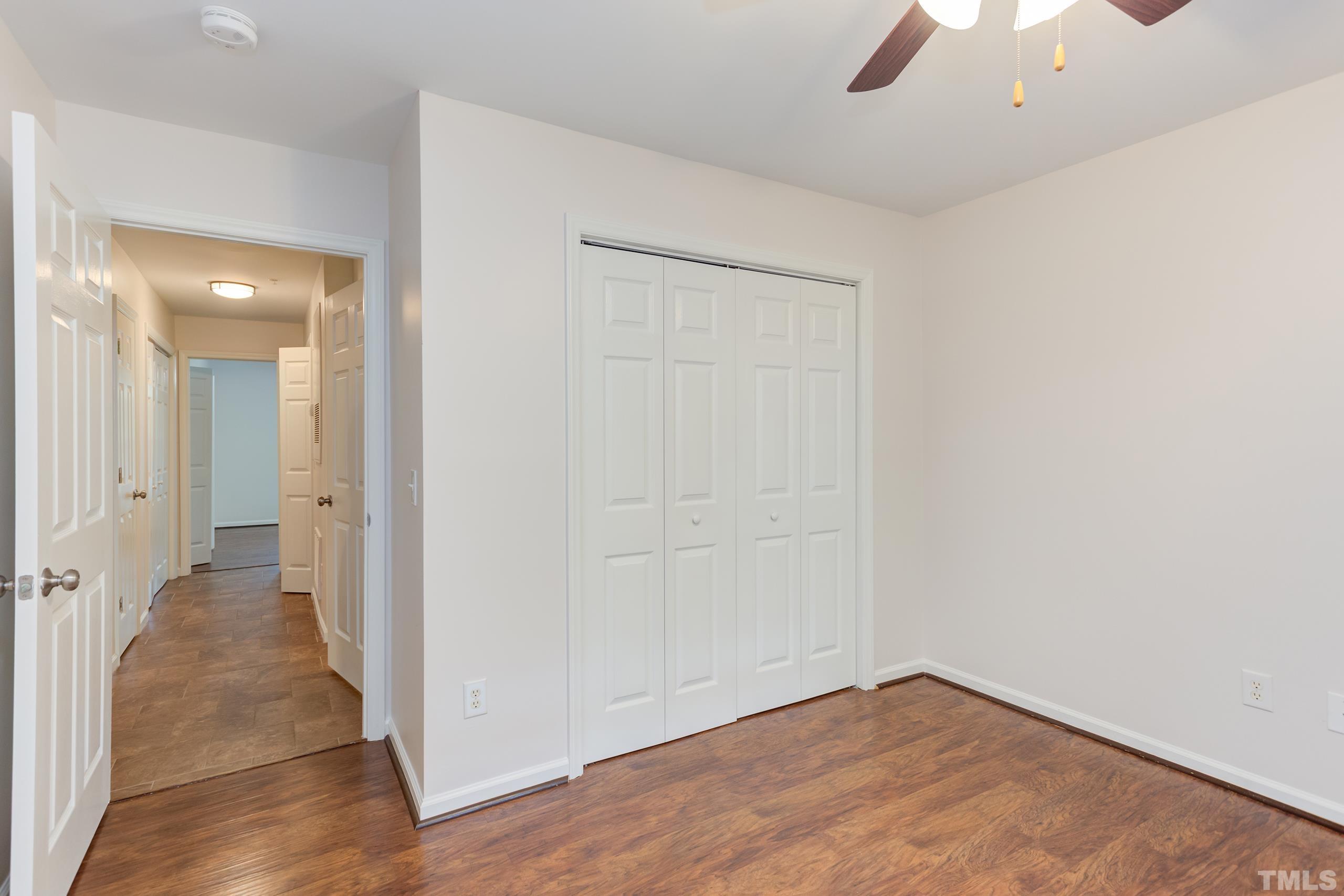 2801 Trailwood Pines Lane, Unit 102 Raleigh, NC 27603 - Photo 16 of 27 an empty room with a hallway and a chandelier fan