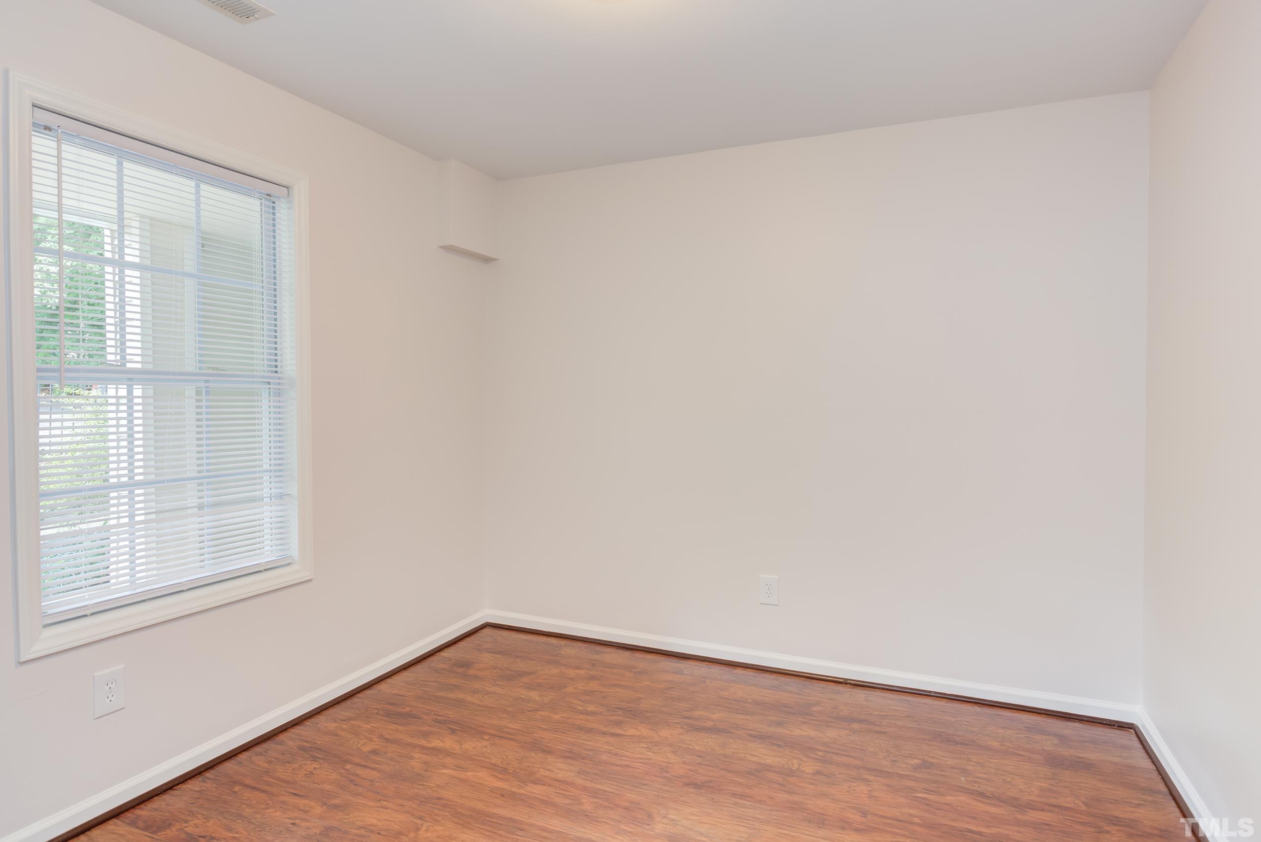 2801 Trailwood Pines Lane, Unit 102 Raleigh, NC 27603 - Photo 3 of 27 a view of an empty room with wooden floor and a window