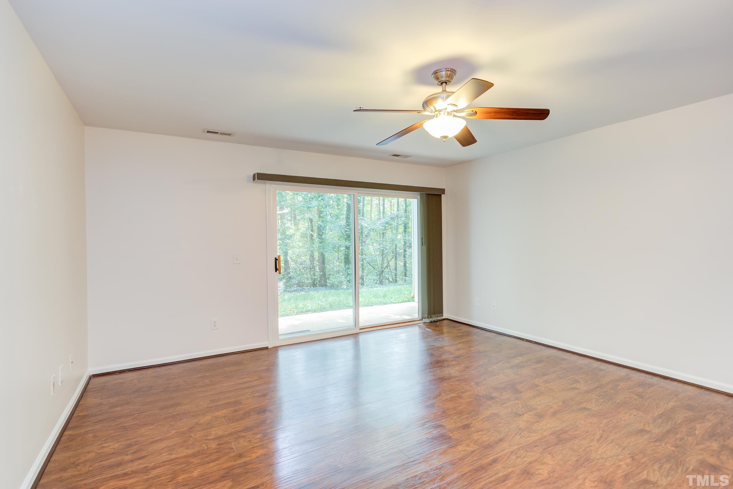 2801 Trailwood Pines Lane, Unit 102 Raleigh, NC 27603 - Photo 7 of 27 an empty room with wooden floor fan and windows