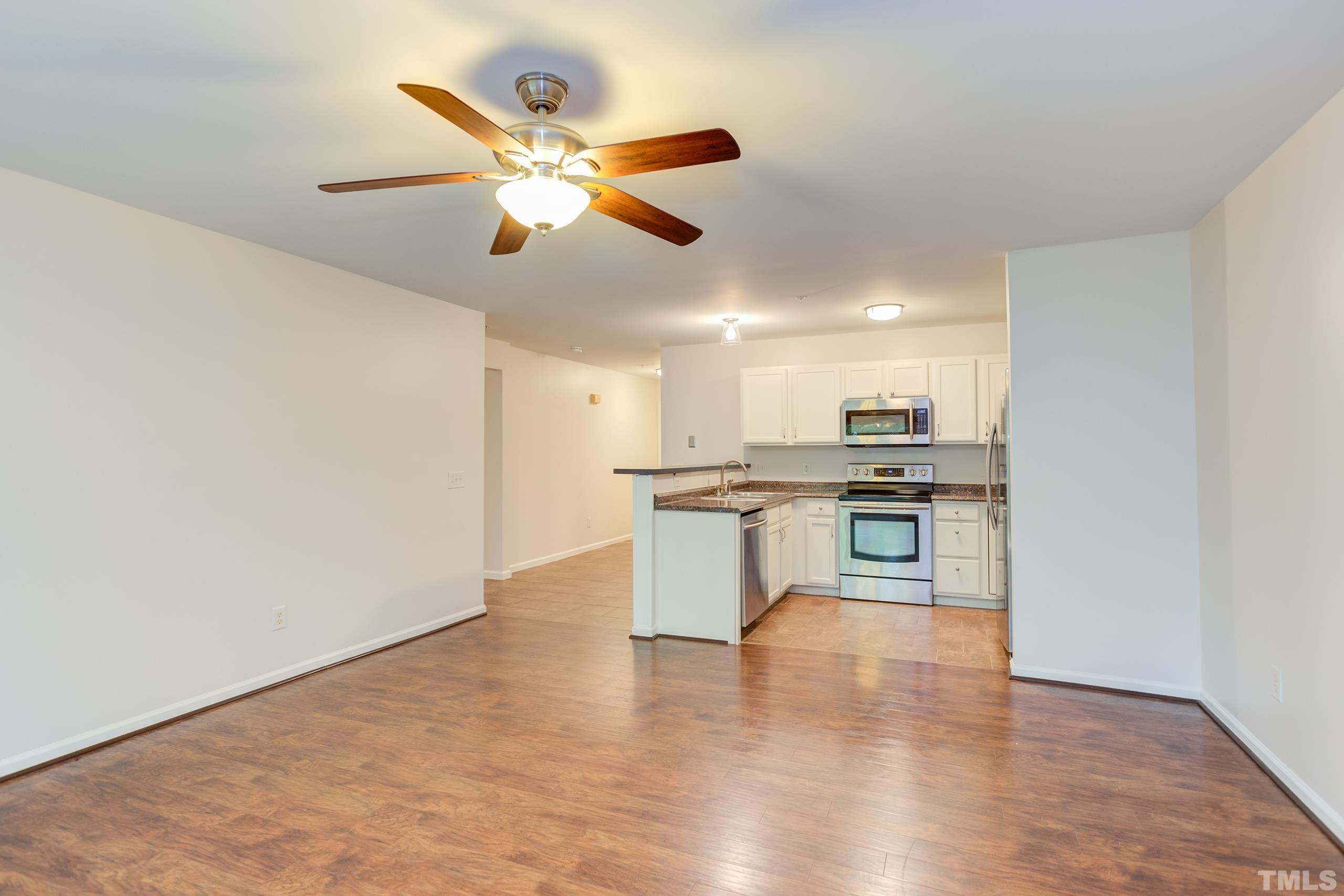 2801 Trailwood Pines Lane, Unit 102 Raleigh, NC 27603 - Photo 8 of 27 a kitchen with kitchen island stainless steel appliances sink cabinets and wooden floor
