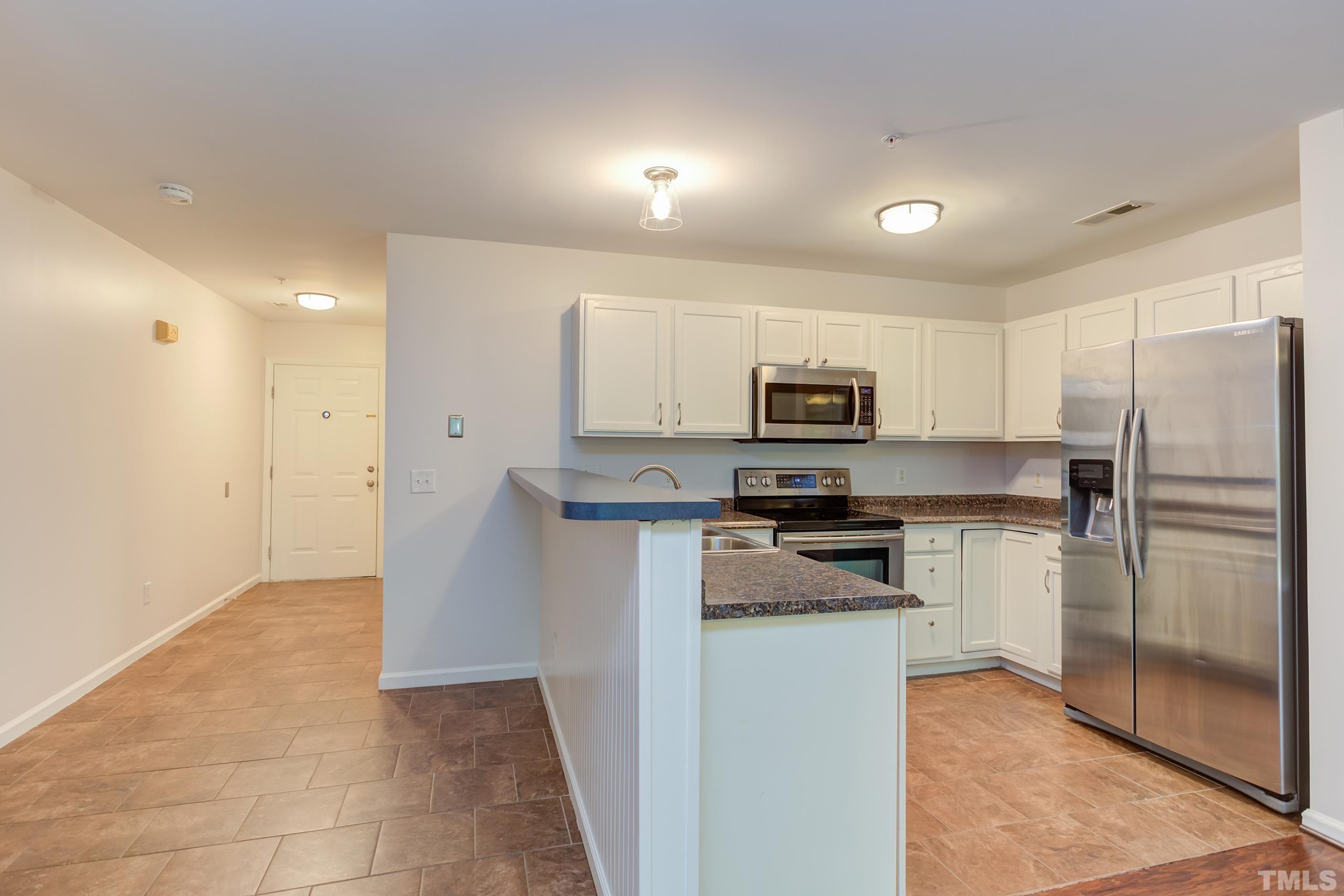 2801 Trailwood Pines Lane, Unit 102 Raleigh, NC 27603 - Photo 10 of 27 a kitchen with stainless steel appliances granite countertop a refrigerator and a stove