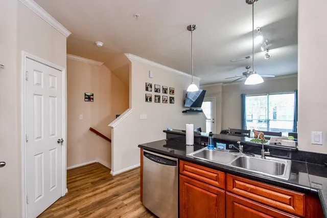a kitchen with stainless steel appliances granite countertop a sink a stove and a wooden floors