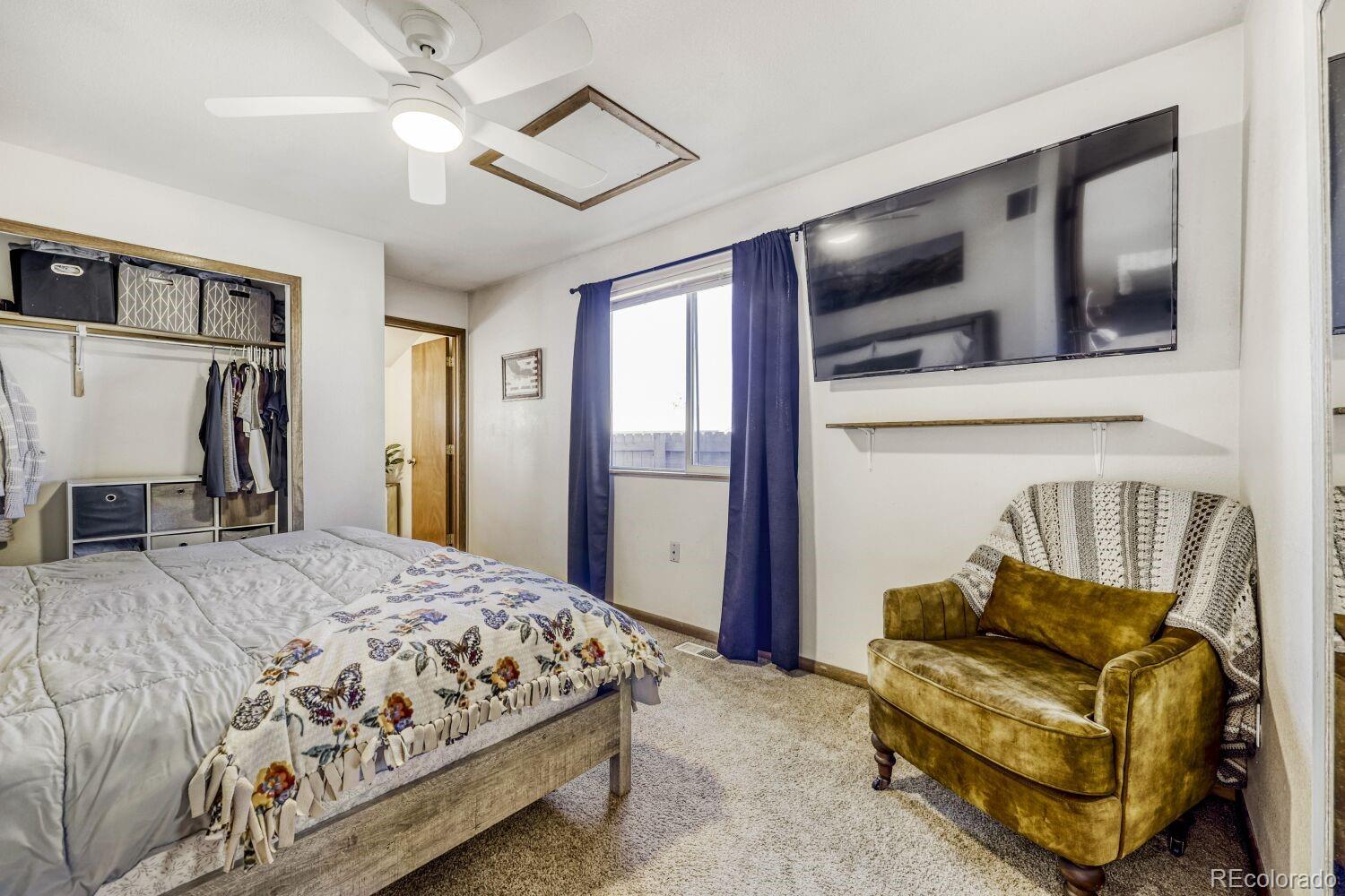 111 7th Street Fort Lupton, CO 80621 - Photo 13 of 22 a bedroom with a bed couch and a large mirror