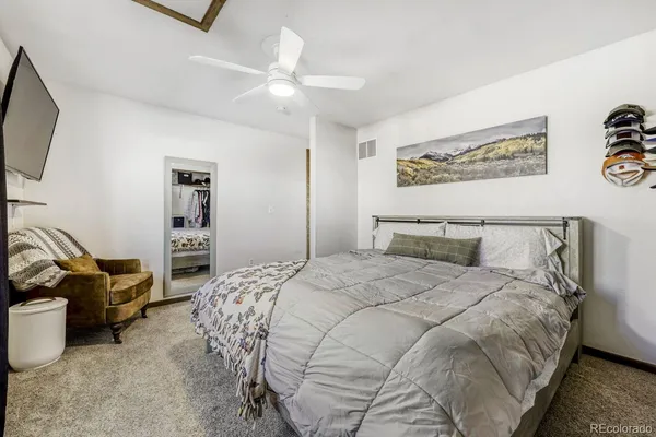 a bedroom with bed and a flat tv screen on dresser