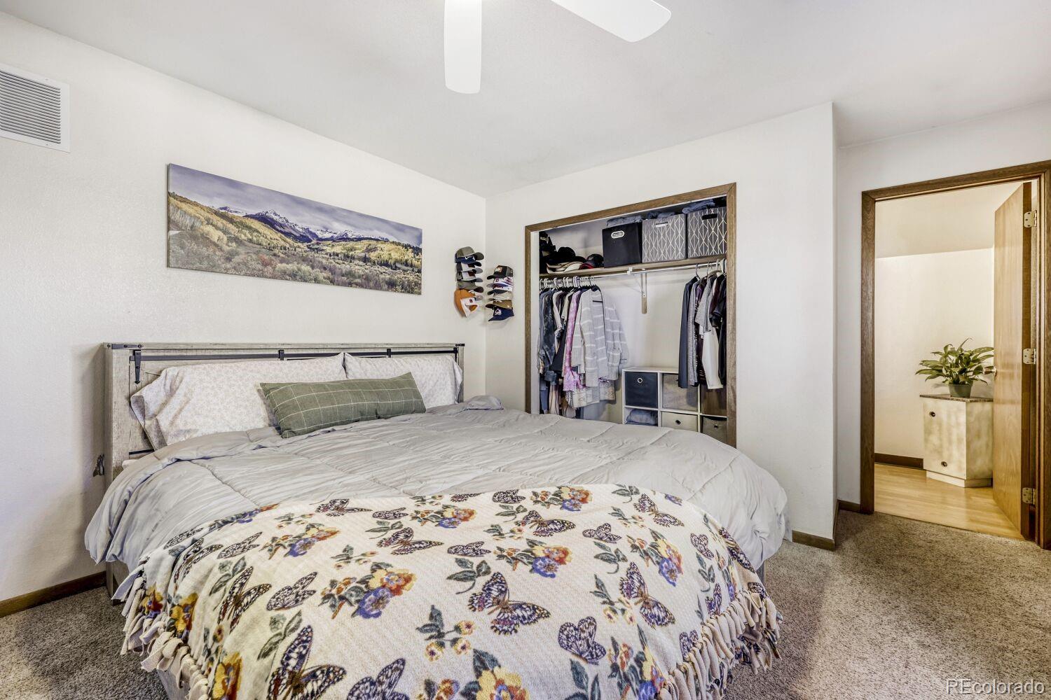 111 7th Street Fort Lupton, CO 80621 - Photo 15 of 22 a bedroom with a large bed and a chandelier