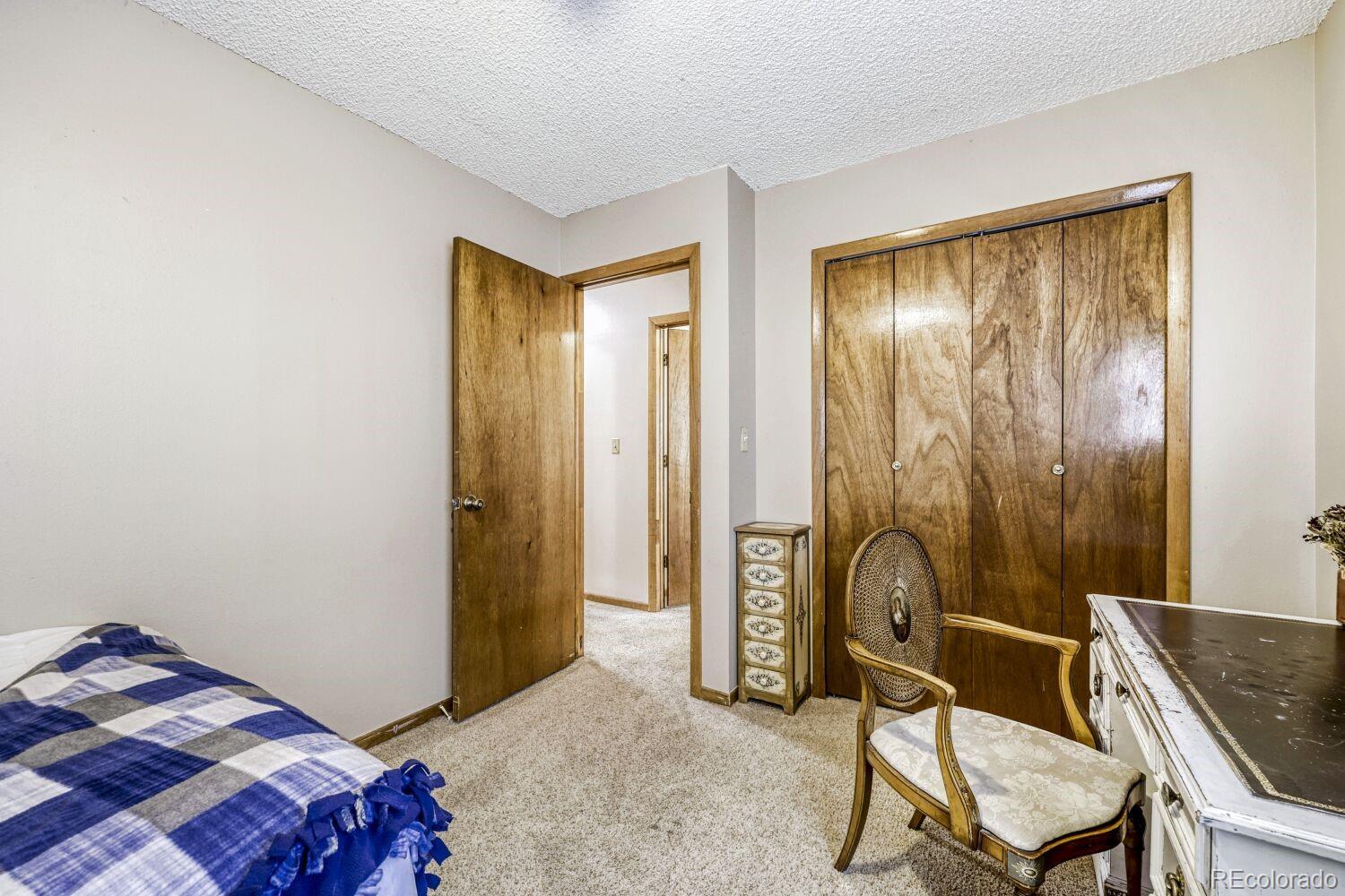111 7th Street Fort Lupton, CO 80621 - Photo 19 of 22 a bedroom with a bed and a chair