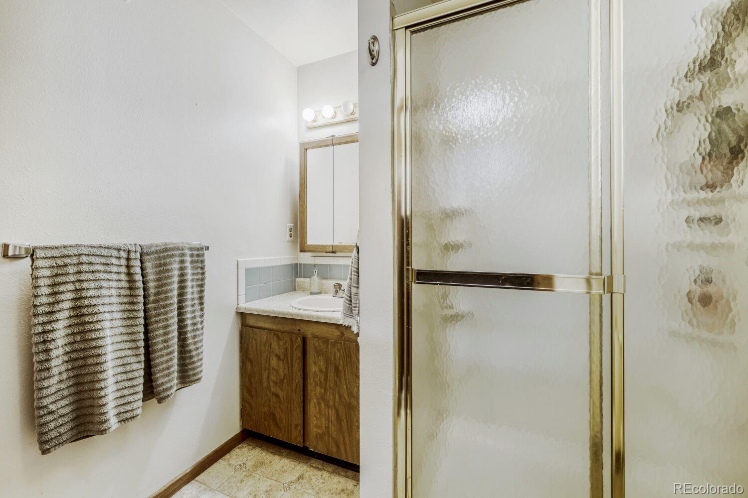 111 7th Street Fort Lupton, CO 80621 - Photo 20 of 22 a bathroom with a shower and a sink