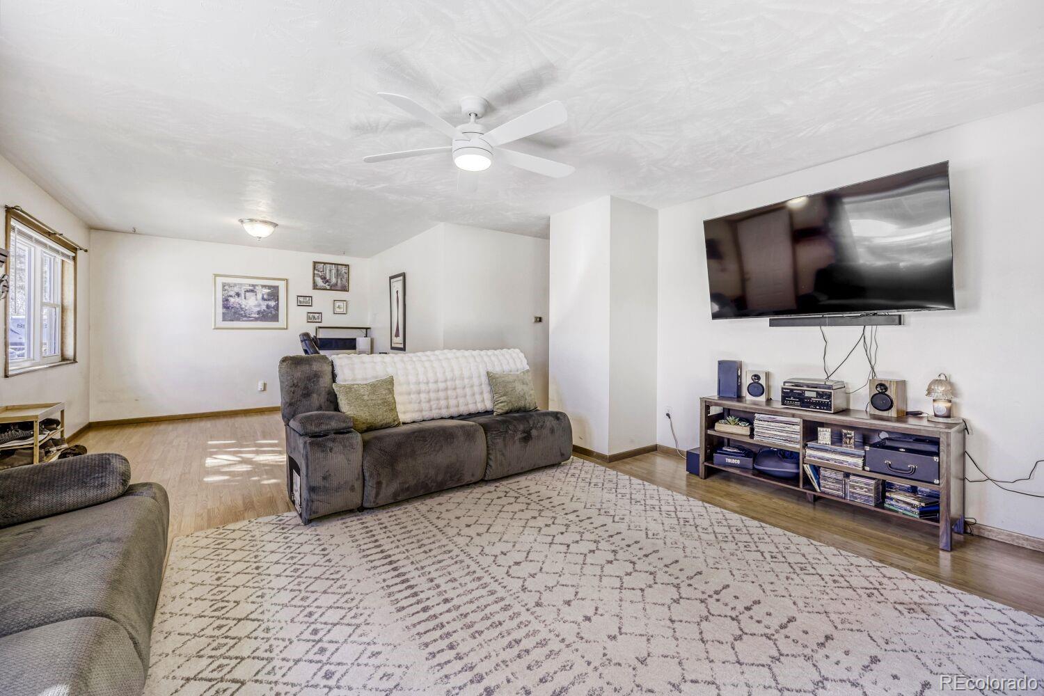 111 7th Street Fort Lupton, CO 80621 - Photo 4 of 22 a living room with furniture and a flat screen tv
