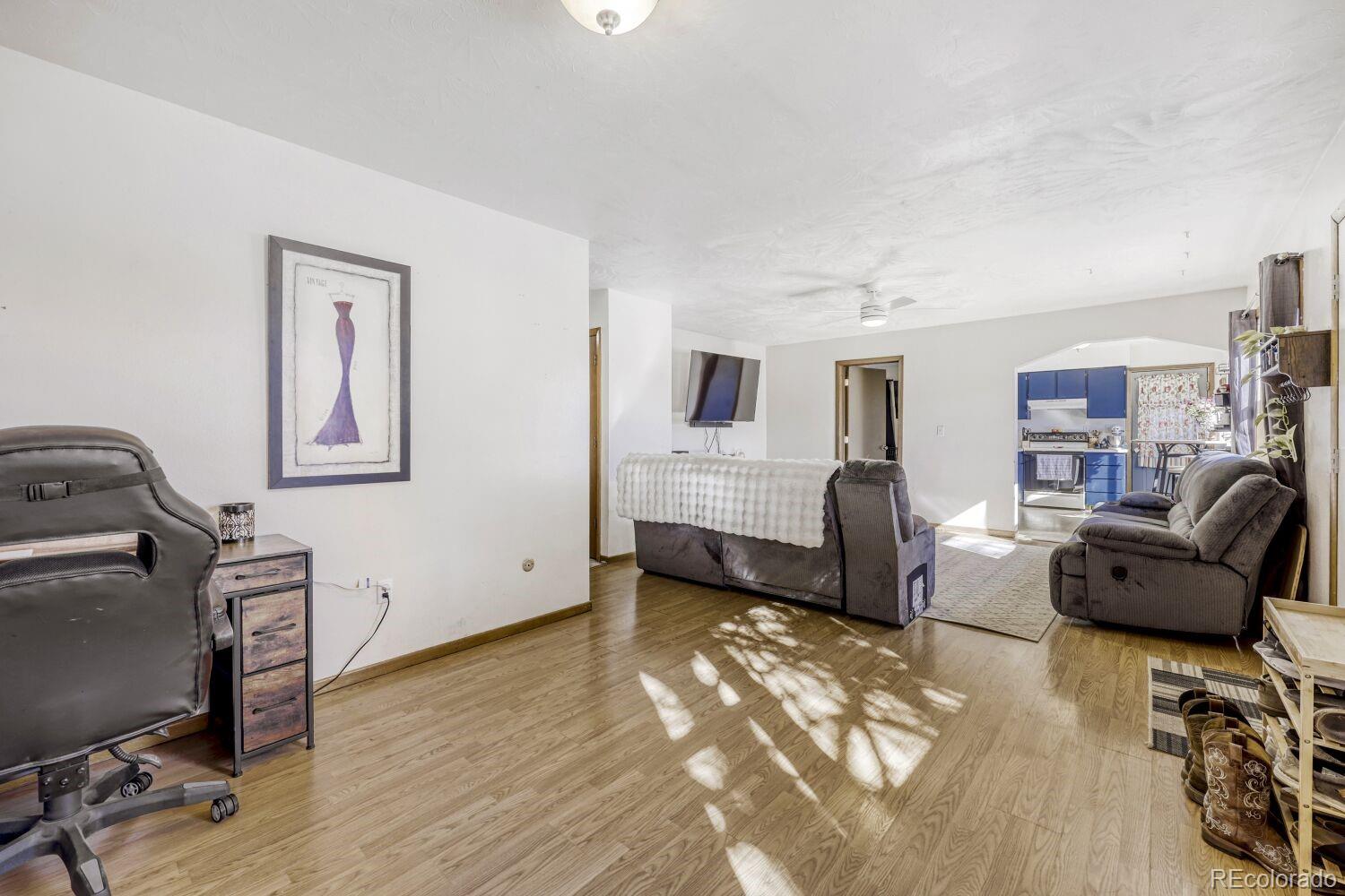 111 7th Street Fort Lupton, CO 80621 - Photo 7 of 22 a living room with furniture and a flat screen tv