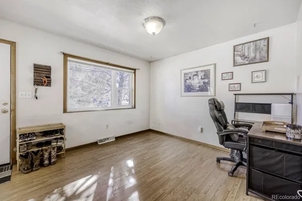 a view of a workspace with furniture and a window