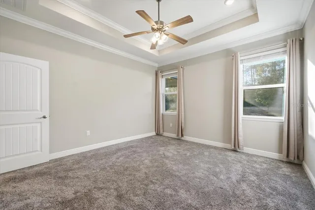 an empty room with fan and windows