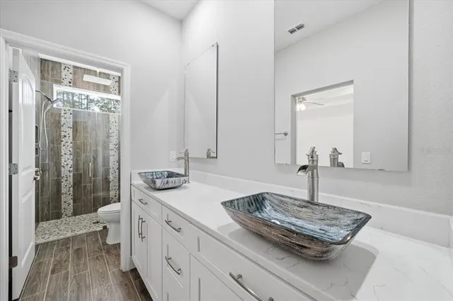 a bathroom with a granite countertop sink and a mirror