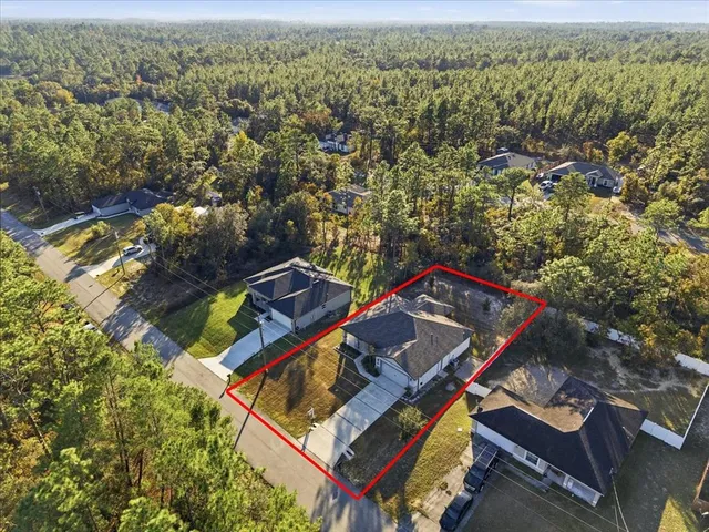 an aerial view of a house with a yard and lake view