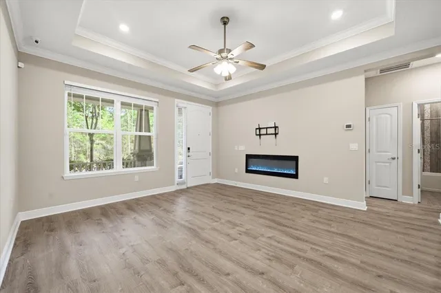 an empty room with windows and a ceiling fan