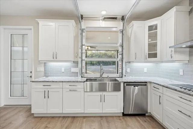 a kitchen with white cabinets and sink