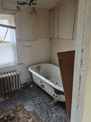 a bathroom with a bathtub and a window