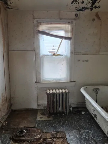 a bathroom with a bathtub a toilet and a window