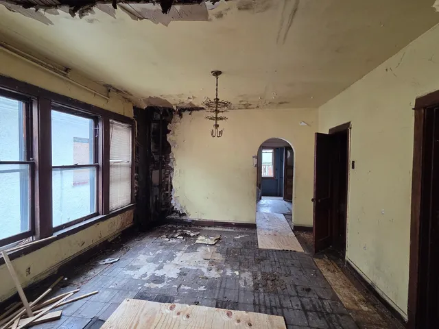 a view of a hallway with entryway and chandelier