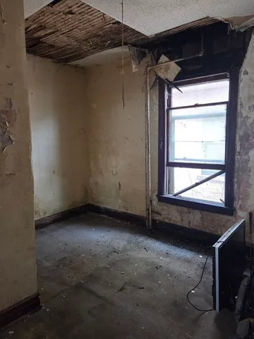 a view of a closet with wooden floor and a window