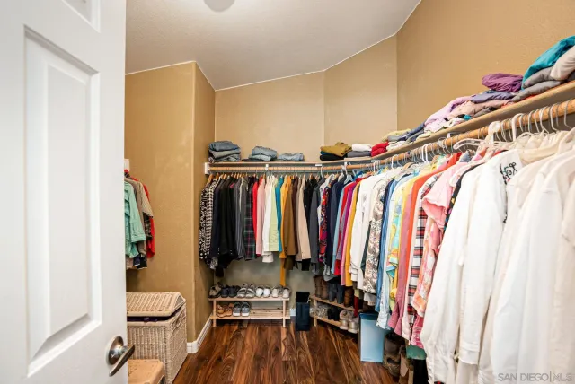 a view of walk in closet with clothes and shoes