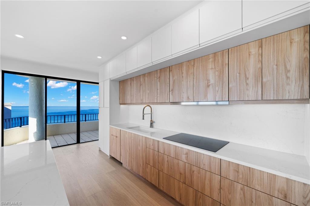 4451 Gulf Shore Boulevard North, Unit 2002 Naples, FL 34103 - Photo 11 of 36 a kitchen with a sink and cabinets