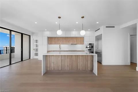 a large kitchen with stainless steel appliances lots of counter space and a sink