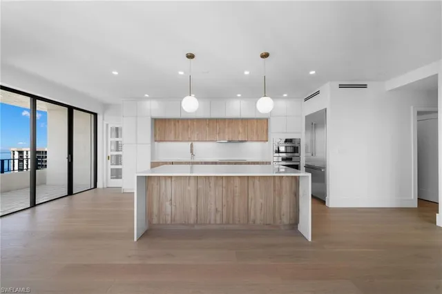 a large kitchen with stainless steel appliances lots of counter space and a sink