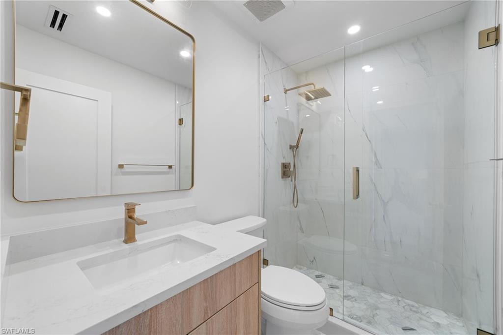 4451 Gulf Shore Boulevard North, Unit 2002 Naples, FL 34103 - Photo 22 of 36 a bathroom with a sink a toilet and shower