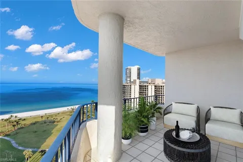a balcony with outdoor seating and plants
