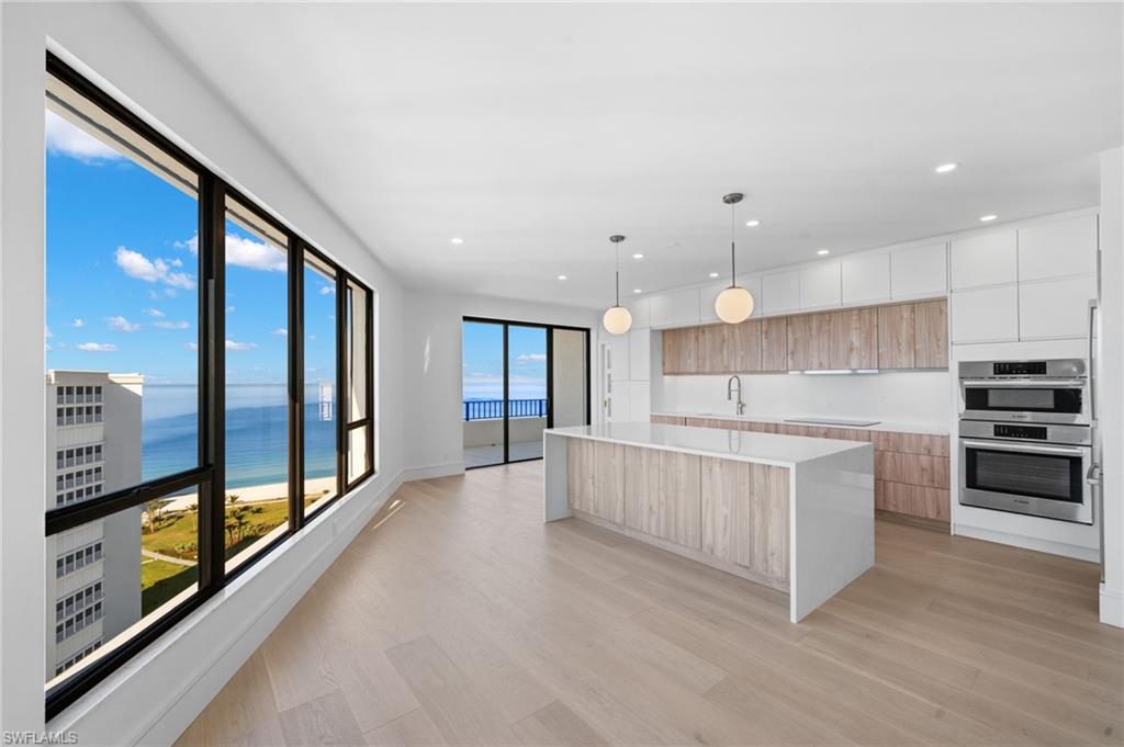 4451 Gulf Shore Boulevard North, Unit 2002 Naples, FL 34103 - Photo 4 of 36 a large kitchen with stainless steel appliances kitchen island a large counter top and a wooden floors