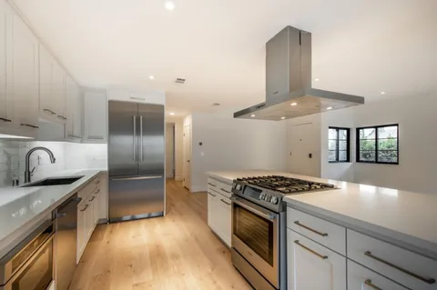 a kitchen with stainless steel appliances granite countertop a sink stove and refrigerator