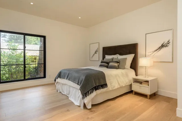 a bed sitting in a bedroom next to a window