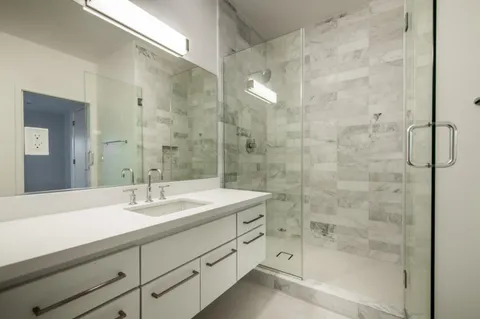 a bathroom with a shower sink and mirror