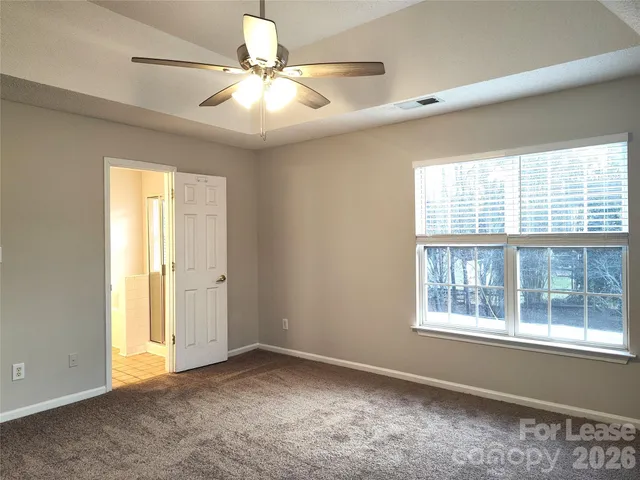 an empty room with windows and fan