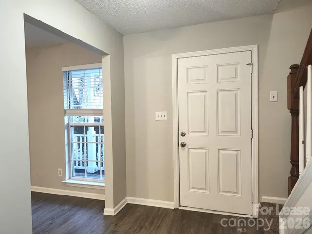 an empty room with wooden floor door and windows