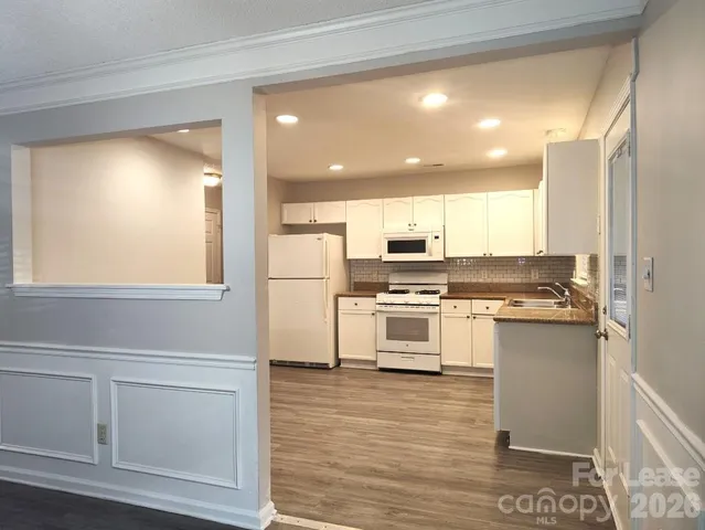 a kitchen with a refrigerator and white cabinets