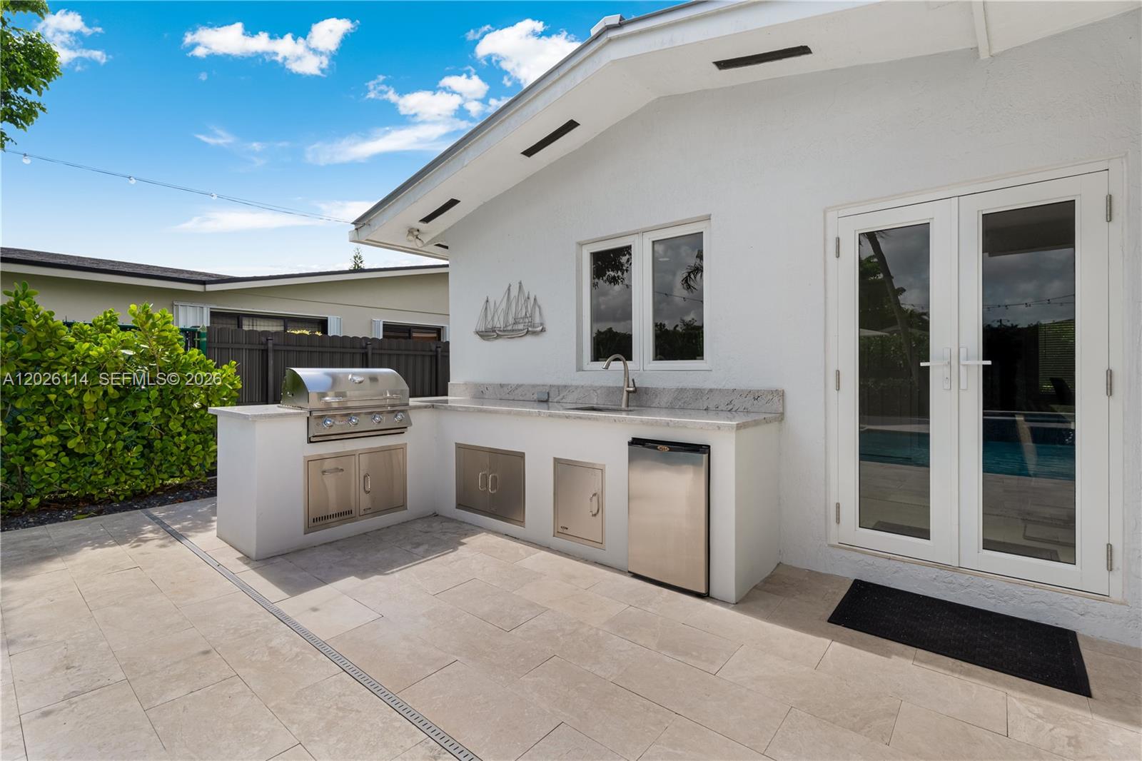 9641 Southwest 66th Street Miami, FL 33173 - Photo 39 of 57 a white kitchen with stainless steel appliances granite countertop a stove and a sink with couches