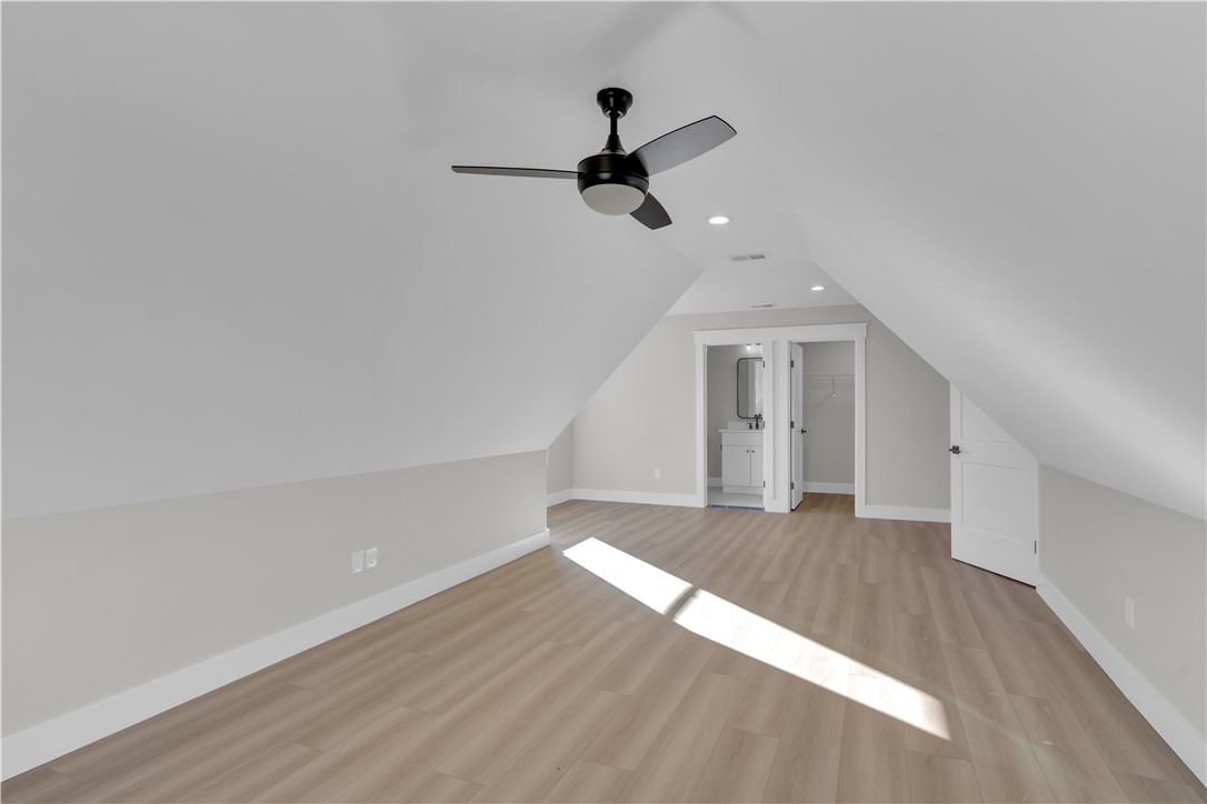 516 Lakeside Drive Anderson, SC 29621 - Photo 29 of 32 Sloped ceilings and recessed lighting define this versatile attic space with hardwood-style flooring and an adjacent bathroom.