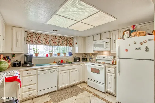 a kitchen with white cabinets sink and white appliances