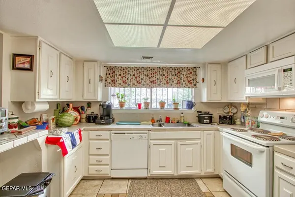 a kitchen with cabinets appliances a sink and a counter top space