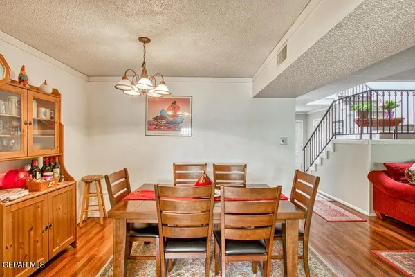 a dining room with wooden floor a chandelier a wooden table and chairs
