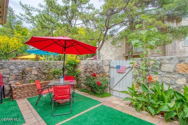 a view of a backyard with sitting area and umbrella