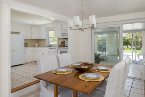 a view of a dining room with furniture large windows and wooden floor