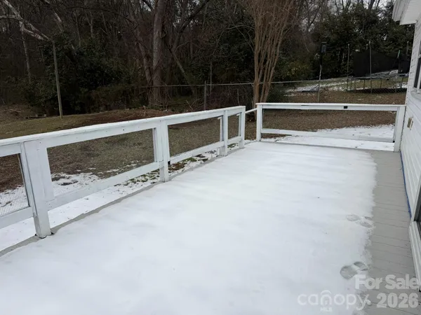 a view of backyard with white door and wooden fence