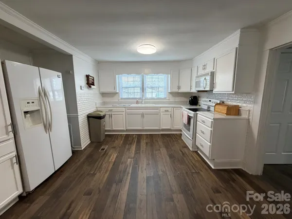 a kitchen with wooden floors and refrigerator