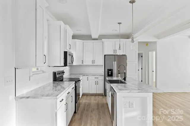 a kitchen with stainless steel appliances granite countertop a sink stove and refrigerator