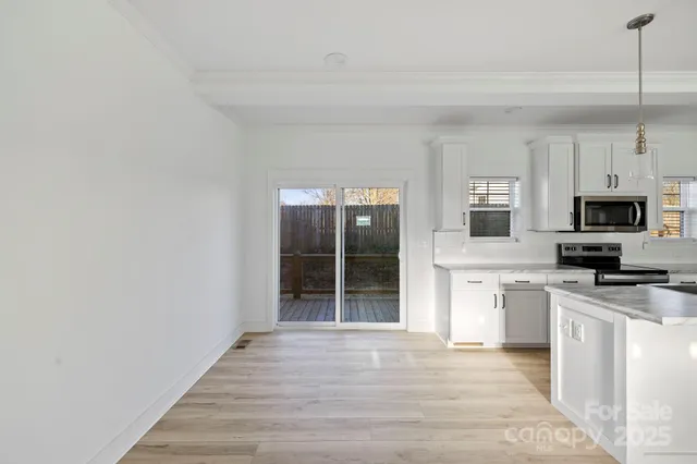 a view of a kitchen with a sink wooden floor and a living room