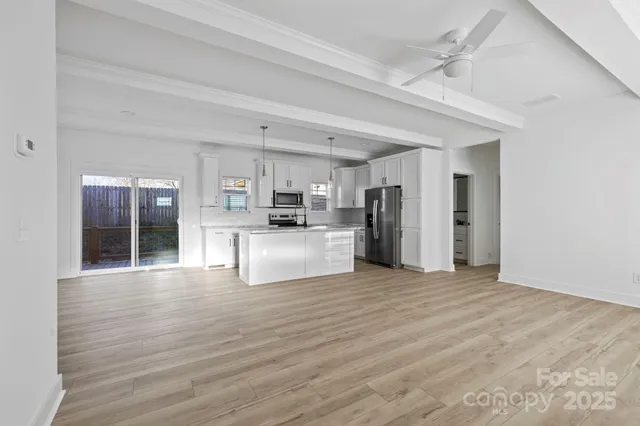 a view of kitchen with refrigerator microwave and wooden floor
