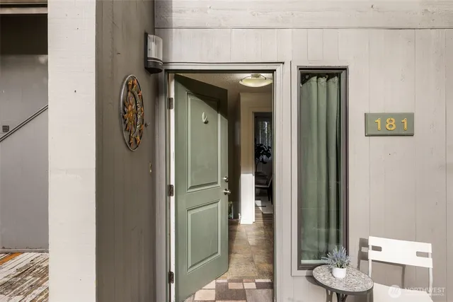 a view of a hallway with wooden floor and a dining room